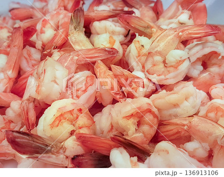 Close-up pile of fresh cooked pink shrimp with tails attached. Boiled prawns ready for serving as a seafood appetizer or cocktail. focusing on texture and color. Close-up pile of fresh cooked pink shrimp with tails attached. Boiled prawns ready for serving as a seafood appetizer or cocktail. focusing on texture and color. 136913106