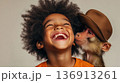 Joyful interaction between a child and a monkey in a playful indoor setting captured during a fun moment filled with laughter 136913261