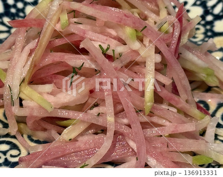 Shredded watermelon radish salad on porcelain plate with intricate patterns Shredded watermelon radish salad on porcelain plate with intricate patterns 136913331