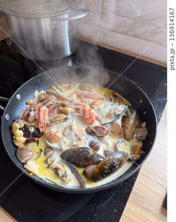 Seafood stew with mussel clam shrimp and creamy broth in pan. Mediterranean cuisine, home gastronomy, nourishment ritual, and comfort food concept Seafood stew with mussel clam shrimp and creamy broth in pan. Mediterranean cuisine, home gastronomy, nourishment ritual, and comfort food concept 136914167