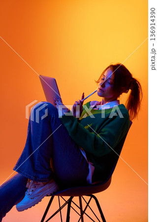 Creative professional sketching ideas on tablet in studio with vibrant gradient lighting. Creative professional sketching ideas on tablet in studio with vibrant gradient lighting. 136914390