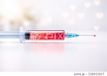 Medical syringe filled with red liquid isolated on light background conceptual healthcare injection 136915817