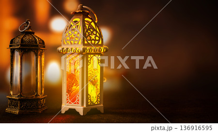 Two decorative Arabic lanterns with intricate patterns glowing warmly against a dark, out-of-focus background. Ideal for Ramadan, Eid al-Fitr, and Islamic holiday themes Two decorative Arabic lanterns with intricate patterns glowing warmly against a dark, out-of-focus background. Ideal for Ramadan, Eid al-Fitr, and Islamic holiday themes 136916595