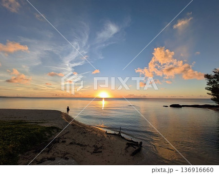 沖縄の海岸の夕日と光の道 静かな海辺を歩く人のシルエット 沖縄の海岸の夕日と光の道 静かな海辺を歩く人のシルエット 136916660