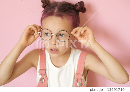 The girl puts on her eyeglasses and is surprised at her clear vision.  World Sight Day 136917104