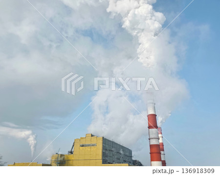 Industrial chimney emitting smoke and steam into the sky. Air pollution from power plant. Environmental concept. Global warming. Industrial chimney emitting smoke and steam into the sky. Air pollution from power plant. Environmental concept. Global warming. 136918309