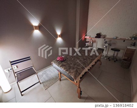 Empty massage table with soft blanket in a cozy room, offering a spa and wellness concept for relaxation and professional therapy. Empty massage table with soft blanket in a cozy room, offering a spa and wellness concept for relaxation and professional therapy. 136918402