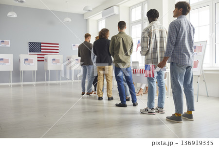 Large diverse group of people registering at polling station holding American flags on election day Large diverse group of people registering at polling station holding American flags on election day 136919335