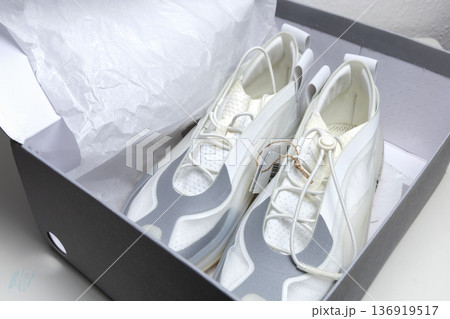 Modern white athletic sneakers inside open shoe box Modern white athletic sneakers inside open shoe box 136919517