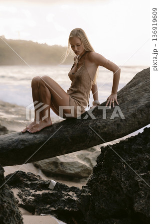 Pretty blonde woman posing between rocks on beach Pretty blonde woman posing between rocks on beach 136919609