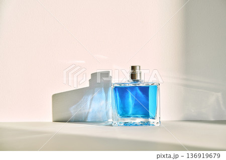 Blue fragrance bottle casting shadow on wall Blue fragrance bottle casting shadow on wall 136919679