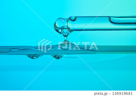 Dropper dispensing blue liquid into a solution Dropper dispensing blue liquid into a solution 136919681