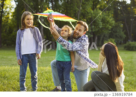 Happy Caucasian father play kite with two kids during family leisure outdoors Happy Caucasian father play kite with two kids during family leisure outdoors 136919784