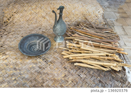 An antique oriental jug and a bowl sit on a woven rug An antique oriental jug and a bowl sit on a woven rug 136920376