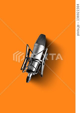 Podcast microphone on an orange background for recording discussions and interviews 136921564