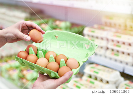 Hands with packing eggs in shop Hands with packing eggs in shop 136921863