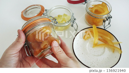 Preparing candied citrus fruits for jars. Sweets and traditional food in Italy. Kumquats, orange peels, and citron. Seasonal, high-quality European farm products. Preparing candied citrus fruits for jars. Sweets and traditional food in Italy. Kumquats, orange peels, and citron. Seasonal, high-quality European farm products. 136921940