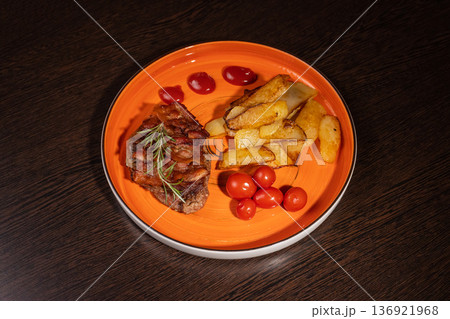 Steak with fried potatoes and tomatoes on a plate Steak with fried potatoes and tomatoes on a plate 136921968