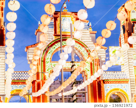 Night view of colorful paper lanterns and illuminated fairground entrance at dusk Night view of colorful paper lanterns and illuminated fairground entrance at dusk 136921972