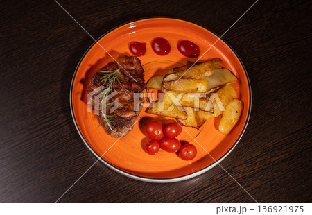 Steak with fried potatoes and tomatoes on a plate Steak with fried potatoes and tomatoes on a plate 136921975