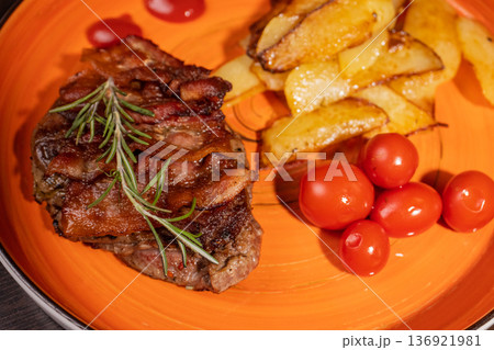 Steak with fried potatoes and tomatoes on a plate 136921981