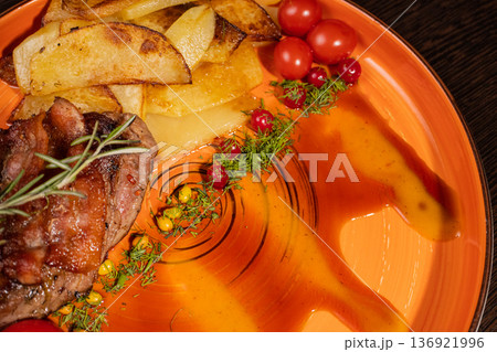 Fried potatoes with a piece of meat on a plate 136921996
