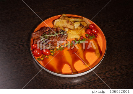 Fried potatoes with a piece of meat on a plate Fried potatoes with a piece of meat on a plate 136922001