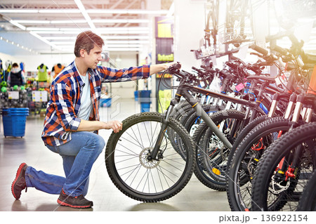 Man checks bicycle in shop Man checks bicycle in shop 136922154