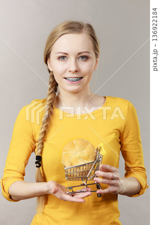 Woman holding shopping cart with bread 136922184