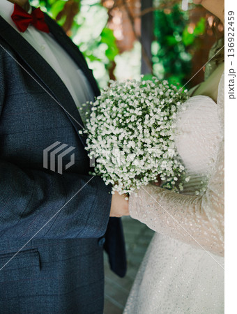 The bride and groom are holding a wedding bouquet The bride and groom are holding a wedding bouquet 136922459