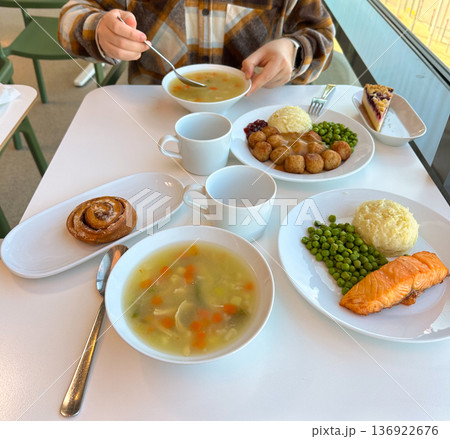 Hearty lunch served at a bright, modern cafe with a variety of dishes. Warm inviting atmosphere and delicious food create a perfect setting for a relaxed dining experience 136922676