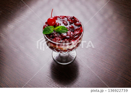 Dessert of pickled cherries with cream in a glass 136922739