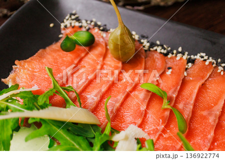 A plate with sliced red fish, bread and greens A plate with sliced red fish, bread and greens 136922774
