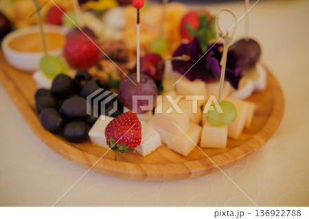 A plate with assorted cheeses, fruits, nuts and 136922788