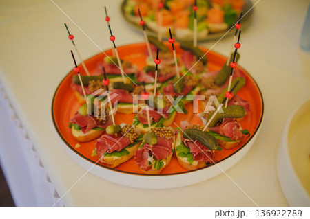 Appetizers on skewers with cold meats 136922789