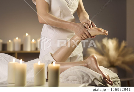 Relaxing foot massage therapy in spa, candles and towels, professional care 136922941