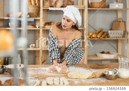 Alluring naked woman in open plaid shirt kneading dough Alluring naked woman in open plaid shirt kneading dough 136924389
