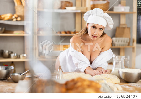Woman in unbuttoned chef uniform posing in workshop Woman in unbuttoned chef uniform posing in workshop 136924407