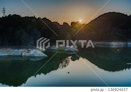 2026早春　渇水が続く布目ダムで対岸の山並みに沈んで行く夕日⑤ 136924837