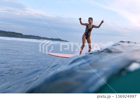 Peaceful Woman Cruises Smoothly Along Shoreline On Her Longboard Peaceful Woman Cruises Smoothly Along Shoreline On Her Longboard 136924997