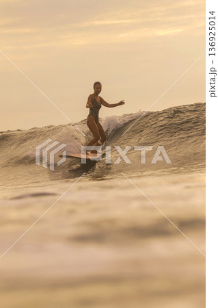 Skilled Surf Coach Performing Sharp Maneuvers In Golden Evening Light Skilled Surf Coach Performing Sharp Maneuvers In Golden Evening Light 136925014