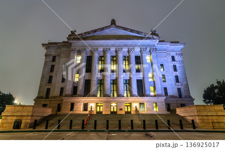 Night view of the illuminated neoclassical architecture of the Oklahoma State Capitol building with wide stairs and tall columns in Oklahoma City, Oklahoma, United States. Night view of the illuminated neoclassical architecture of the Oklahoma State Capitol building with wide stairs and tall columns in Oklahoma City, Oklahoma, United States. 136925017