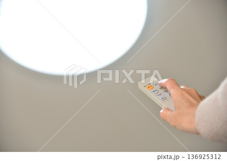 LED照明のリモコンを操作する手元 136925312