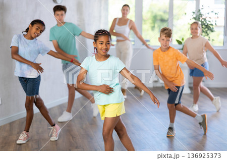 Children exercising contemporary dance moves during their in studio Children exercising contemporary dance moves during their in studio 136925373