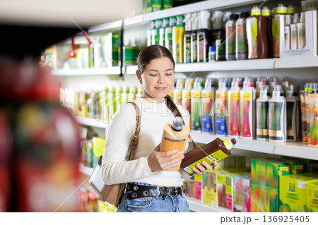 Young woman choosing fertilizers in hardware store Young woman choosing fertilizers in hardware store 136925405