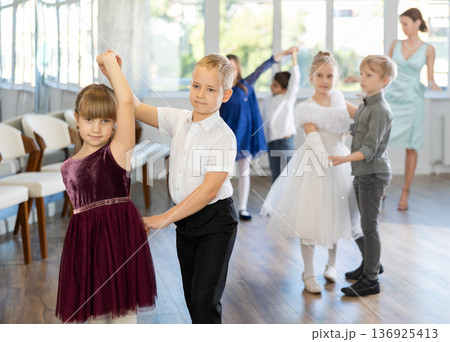 Tween girls ad boys dancing slow partner dance during festive event Tween girls ad boys dancing slow partner dance during festive event 136925413