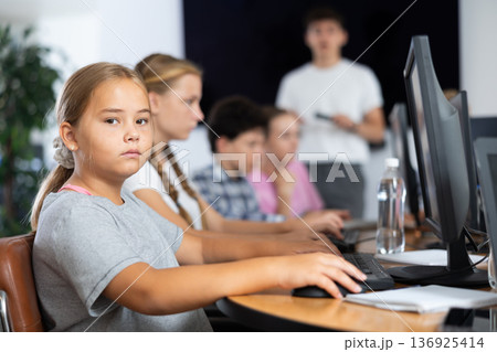 Girl student learning to work on computer in classroom Girl student learning to work on computer in classroom 136925414