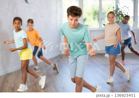 Boy perform choreographic exercises and teach energetic social dance hip hop with friends Boy perform choreographic exercises and teach energetic social dance hip hop with friends 136925451