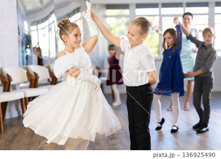 Enthusiastic preteen children dancing waltz in pairs in dance school 136925490
