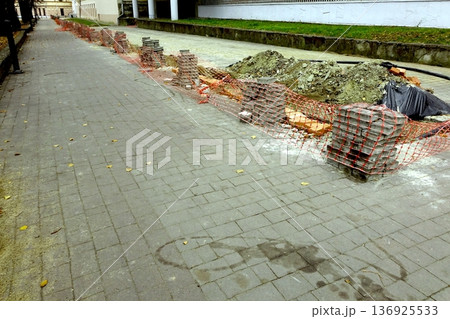 Works Are Fixing the Sidewalk in a Busy Area 136925533